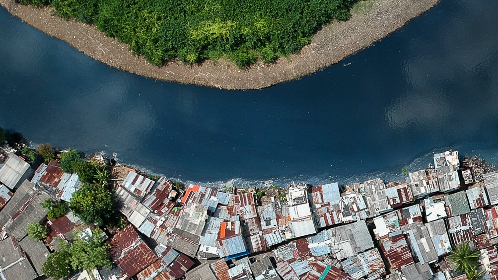 Aerial photograph by Tashiya De Mel of a wetland, river, and dense riverside settlement